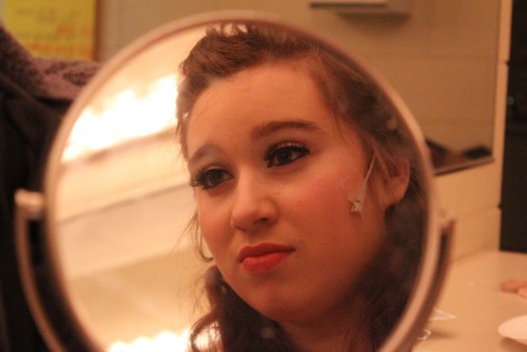 Faith Fuller, who plays Marie, the Fairy Godmother in Cinderella, prepares makeup, costume, and microphone for dress rehearsal.